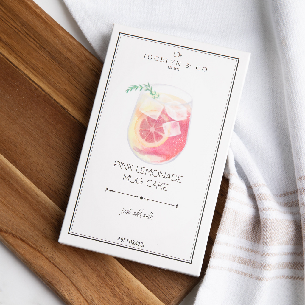 Jocelyn & Co pink lemonade mug cake packaging on a wooden surface with a white towel.