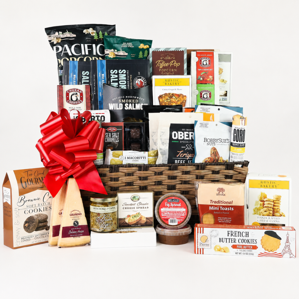 Assorted gourmet food items in a basket with a red bow on a white background